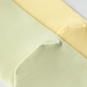 Detail of reinforced heel on candy-colored split toe socks with fine knitted texture