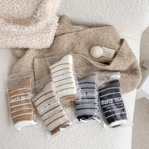 Detail of warm striped fuzzy socks in five colors with soft plush cuffs and gift packaging