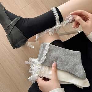 Detailed close-up of sweet Lolita crew socks with lace trim and bow in black, grey and white