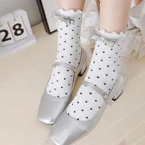 Détail de chaussettes à pois à volants avec nœud argenté et chaussures Mary Jane