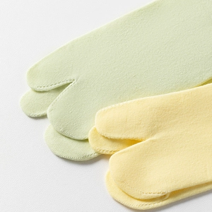 Detailed close-up of cotton blend two-toe socks with fine knit texture in soft pastel colors