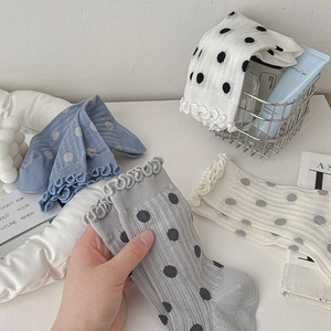 Detail of sweet ruffle cuffs and polka dot pattern on ballet style high cotton socks