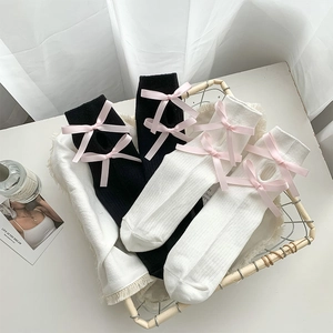 Detail of knit calf socks featuring pink silk bows and oval cutout at the back of cuffs
