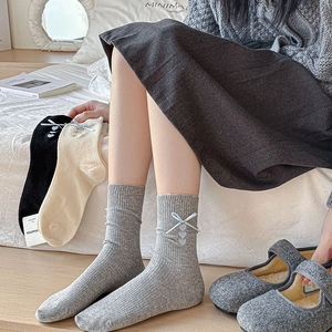 Detail showing soft cotton mid-tube socks with ribbon bows and heart embroidery