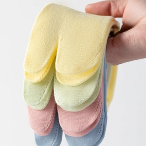 Detail of candy-colored tabi socks showing the split-toe structure and soft cotton texture