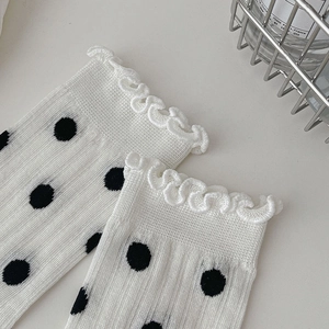 Detail of ballet style white socks with black polka dots and sweet ruffled frill edges