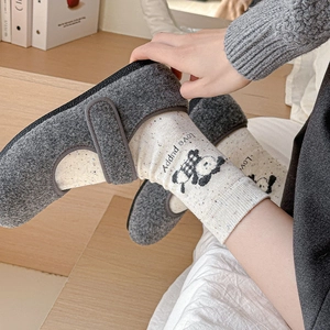 Détail de chaussures Mary Jane en feutre gris foncé avec texture douce et bride velcro