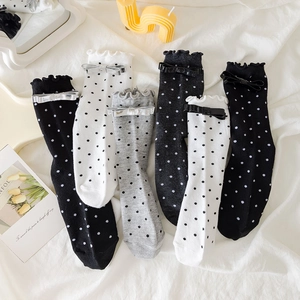 Vue détaillée de chaussettes à pois avec bords à volants et nœuds brillants en divers coloris