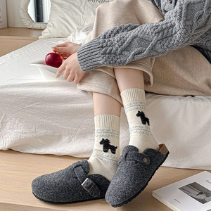 Detail of dark grey felt clogs with metal buckle and heart pattern crew socks