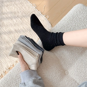 Detailed knit texture of flecked crew socks in black, beige, and gray multi-pack