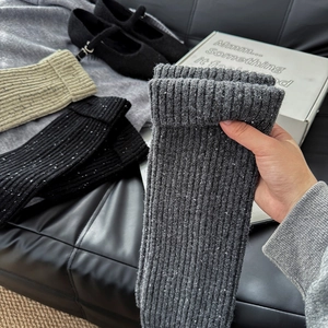 Detailed texture of thick ribbed nepped yarn leg warmers in various autumn colors