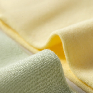 Detailed close-up of soft candy-colored knit fabric showing breathable cotton texture