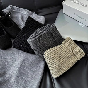 Detail of marled knit leg warmers in black, grey, and beige for winter fashion styling
