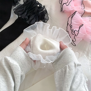 Detailed close-up of Lolita leg warmers with organza ruffles and faux pearl beads