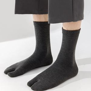 Close-up of dark grey cotton Tabi socks showing split-toe detail and ribbed cuffs