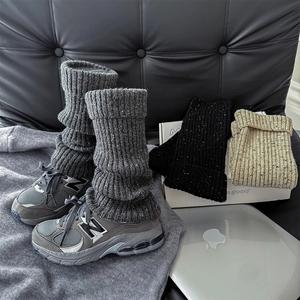 Thick knit leg warmers in dark grey, black, and oatmeal paired with retro sneakers