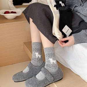 Detail of grey knitted mid-calf socks with white pony pattern and ribbed cuffs for women