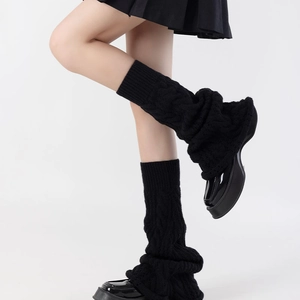 Close-up of black cable knit leg warmers showing detailed texture and patterns