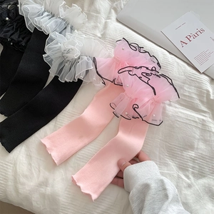 Detail of ruffled organza leg warmers with delicate pearl beads in black, white and pink