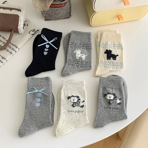 Flat lay of sweet bow socks with cute puppy embroidery and heart patterns in various colors