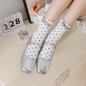 Détail de chaussures Mary Jane argentées avec chaussettes à pois et nœud élégant