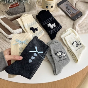 Close-up of knit cotton socks with cute puppy jacquard and blue ribbon bow detail