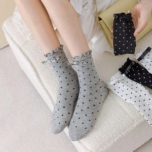 Détail de chaussettes à pois avec nœuds en satin et bords à volants style japonais