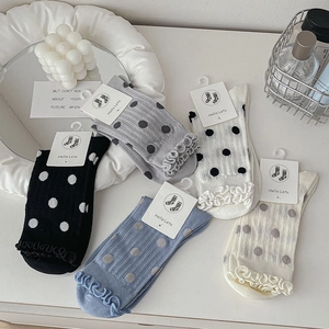 Detail of five-pair polka dot socks set with elegant lettuce edge cuffs in soft tones