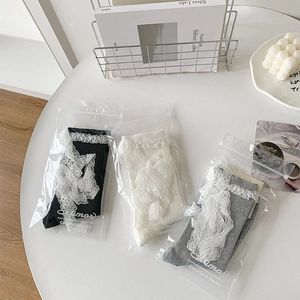 Detailed view of lace-trimmed Lolita socks in premium packaging on a stylized table