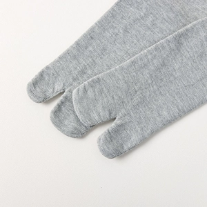 Detail of light gray cotton tabi socks showing fine knitted texture and split-toe stitching