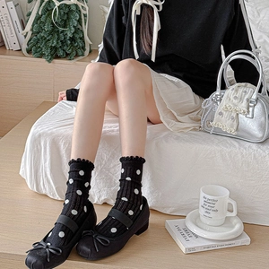 Close-up of ballet style ruffle trim socks with polka dots and Mary Jane shoes