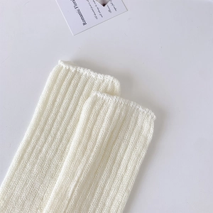 Macro shot of off-white ribbed knit fabric detail and texture for ballet style leg warmers