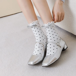 Détail de chaussures Mary Jane argentées avec chaussettes à pois et nœuds doux