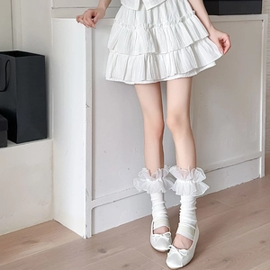 Close-up of Lolita style white leg warmers with organza lace and beaded ruffles