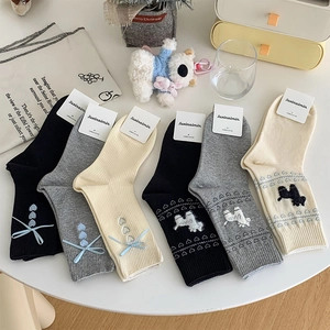 Flat lay of cotton blend mid-calf socks with cute puppy patterns and blue ribbon bows