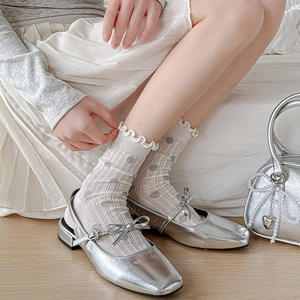 Detail of silver Mary Jane shoes with bow decoration and grey polka dot ruffle socks