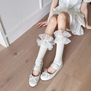 Close-up of white Lolita leg warmers with beaded organza lace and Mary Jane shoes