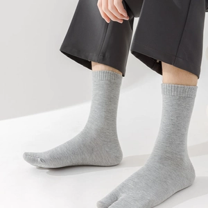Detail of grey Tabi split-toe mid-calf socks with ribbed cuffs and knitted texture