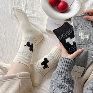 Detail view of cute dog pattern and heart texture on cozy crew socks for women