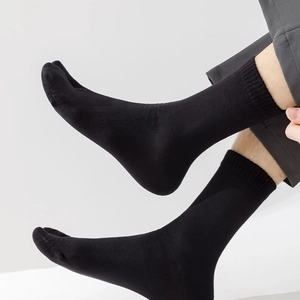 Detail of black cotton tabi crew socks showing ribbed cuffs and premium textured fabric