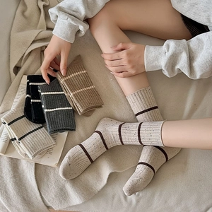 Detail of speckled knit crew socks with vertical ribbing and contrast stripes