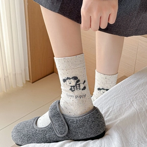 Detail of knit socks with cartoon puppy print and Love Puppy text worn with Mary Janes