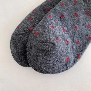 Gros plan détaillé des chaussettes grises à pois montrant la pointe et la texture du coton