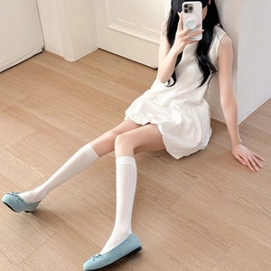 Détail de chaussettes mi-mollet blanches à rayures avec ballerines bleu clair