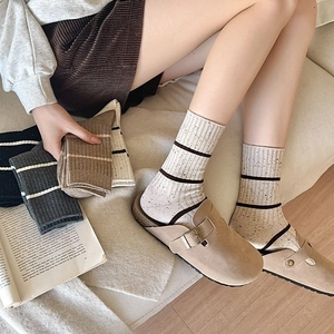 Detail of striped knitted crew socks featuring vintage flecked texture in various colors
