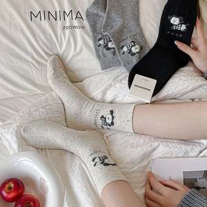 Detail of combed cotton mid-calf socks with cute puppy patterns and bow ribbon accents