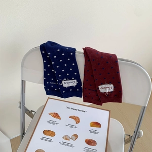 Détail de chaussettes japonaises à pois avec étiquettes en tissu sur une chaise blanche