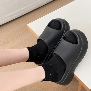 Gros plan sur des sandales noires à plateforme portées avec des chaussettes à pois doux