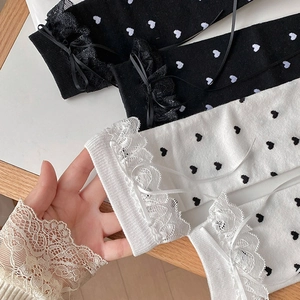Close-up of lace trim and ribbon bows on heart-patterned sweet crew socks