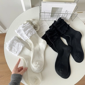 Detail of white and black lace trim mesh socks with vertical ribbing texture